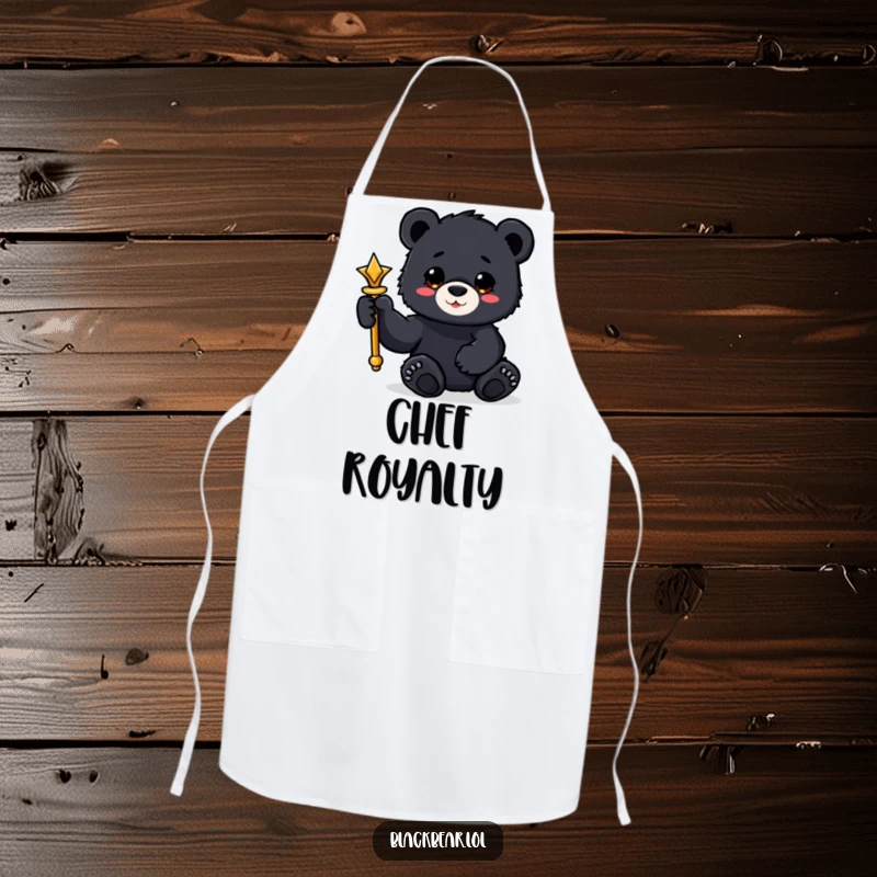 Funny black bear cub apron holding a shiny scepter with a paw, for ruling the kitchen.
