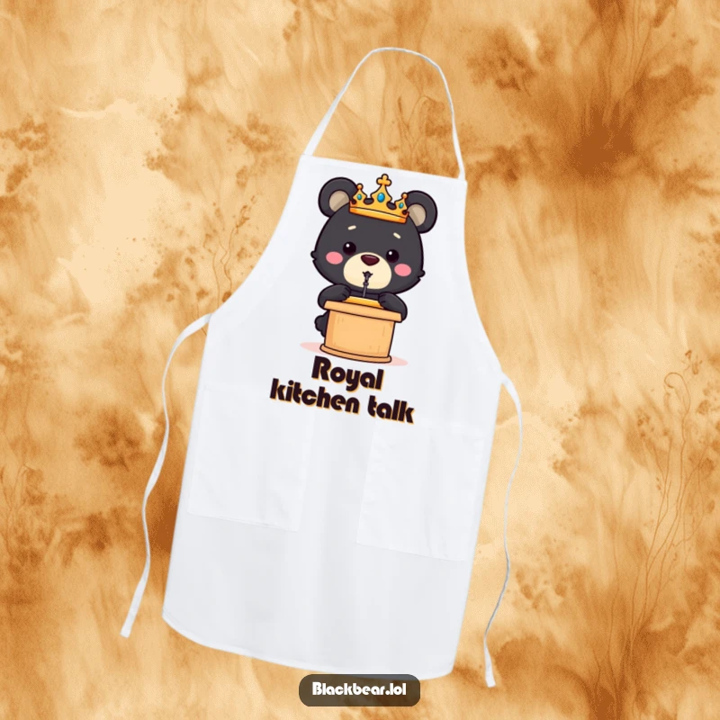 Funny black bear cub wearing a crown gives a speech from a podium while cooking on this humorous apron.