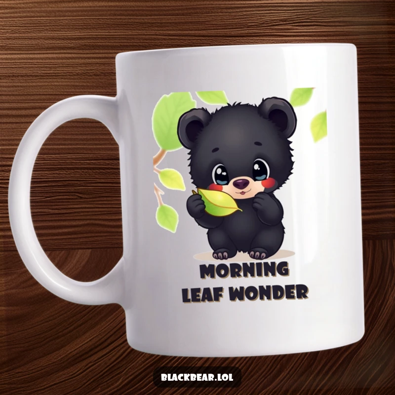Funny mug featuring an adorable black bear cub with wide, inquisitive eyes, intently examining a beautifully shimmering leaf with fascination.