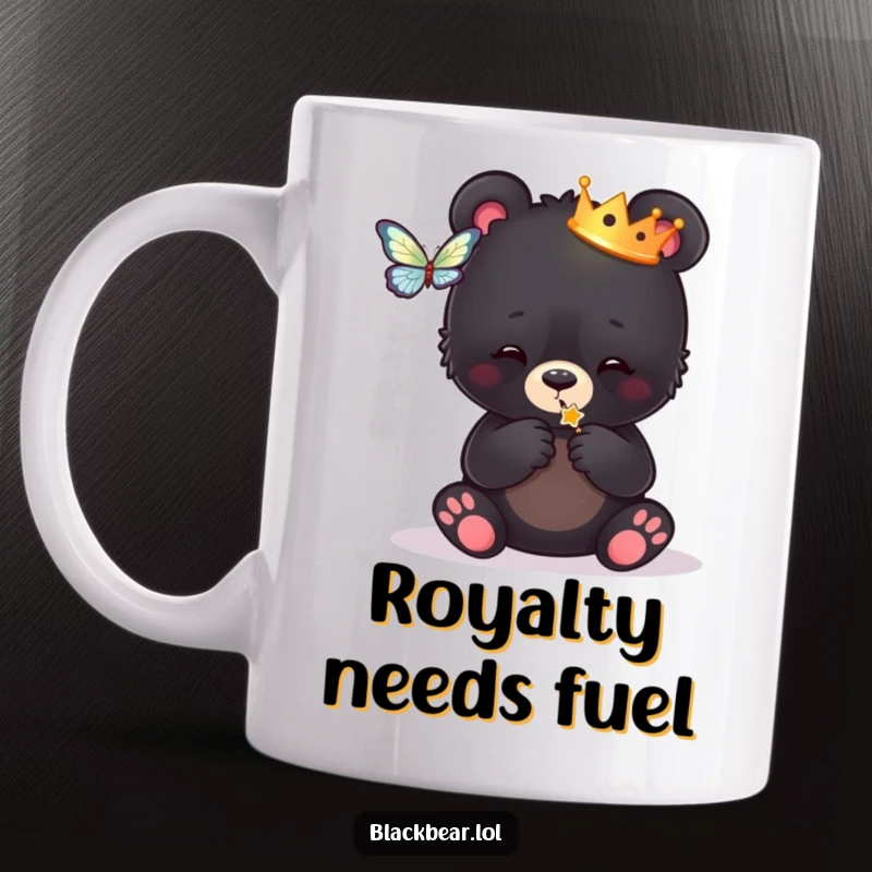Funny mug featuring a black bear cub wearing a tiny crown, playfully batting at a colorful butterfly, looking absolutely regal and cute.