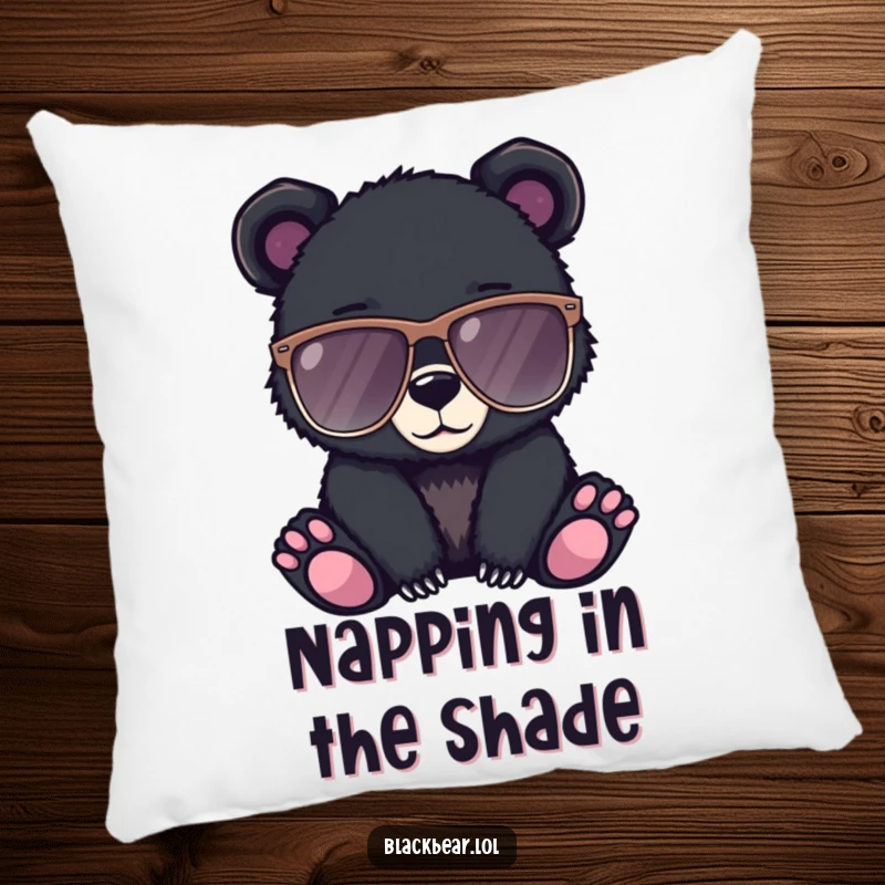 Funny pillow showing a black bear cub wearing oversized sunglasses, looking effortlessly cool and relaxed.