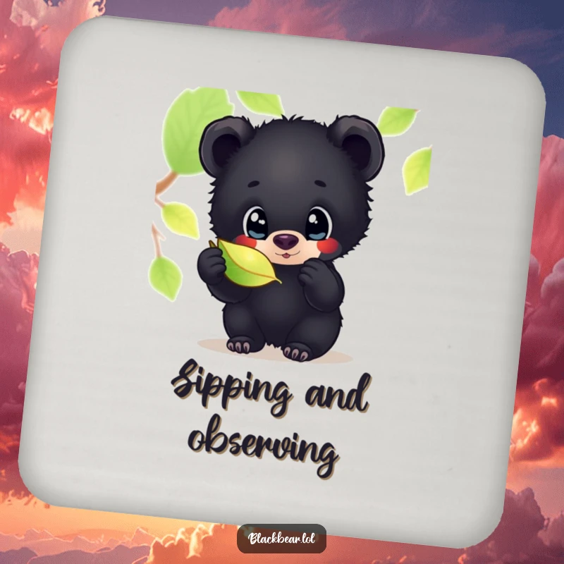 Funny drink coaster featuring a black bear cub with wide, curious eyes, inspecting a shimmering leaf, adding whimsical charm to surfaces.