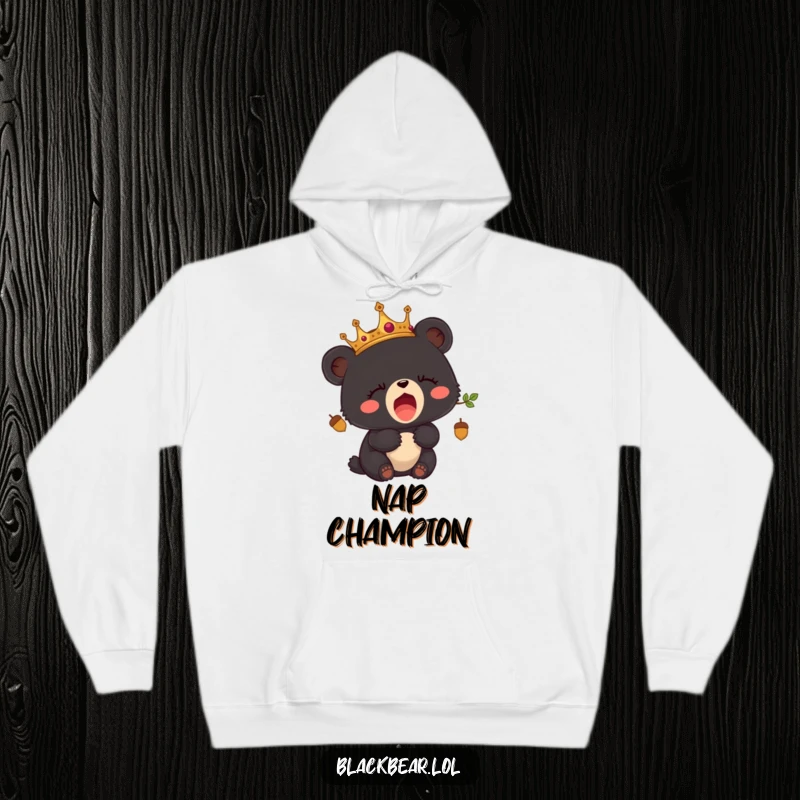 Funny hoodie depicting a sleepy black bear cub wearing a crown made of acorns, yawning adorably.