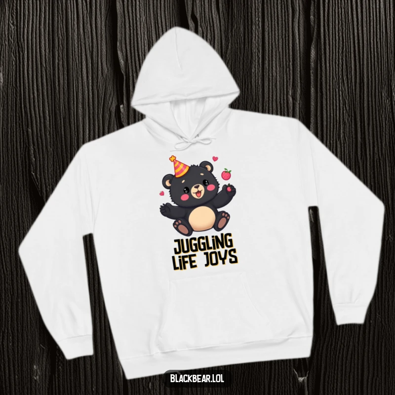 Funny Hoodie: A playful black bear cub wears a party hat and juggles berries with glee, designed for warmth and festive humor.