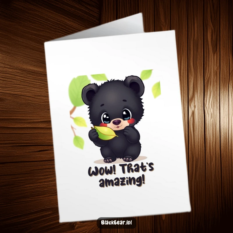 Funny free printable congratulations card showing a black bear cub with big, curious eyes examining a sparkly leaf.