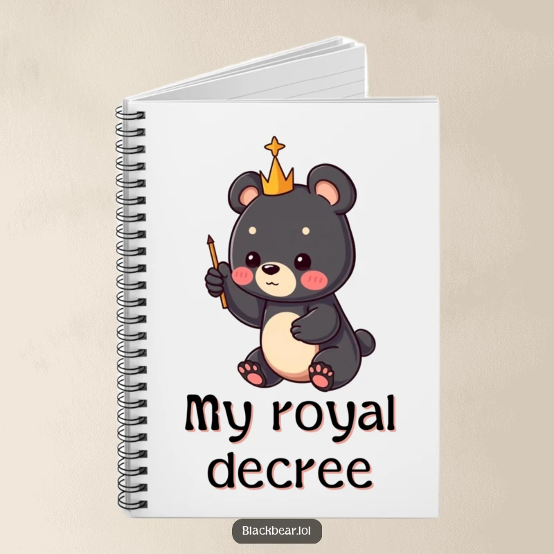 Funny black bear cub with a tiny scepter directing attention skyward, on a notebook cover, a delightful funny gift.