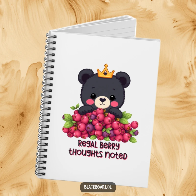 Funny notebook with a cute black bear wearing a crown peeking over a berry bush, perfect for jotting down thoughts with royal flair.