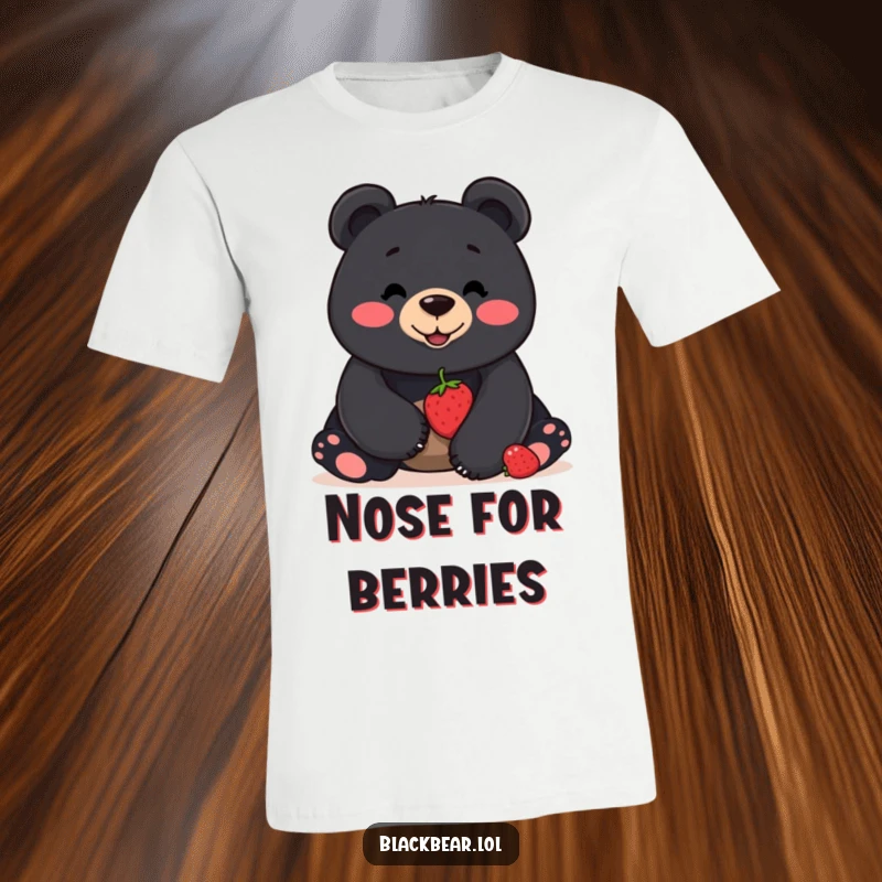 Funny t-shirt featuring a smiling black bear attempting to balance a single berry on its nose, highlighting concentration and charm.