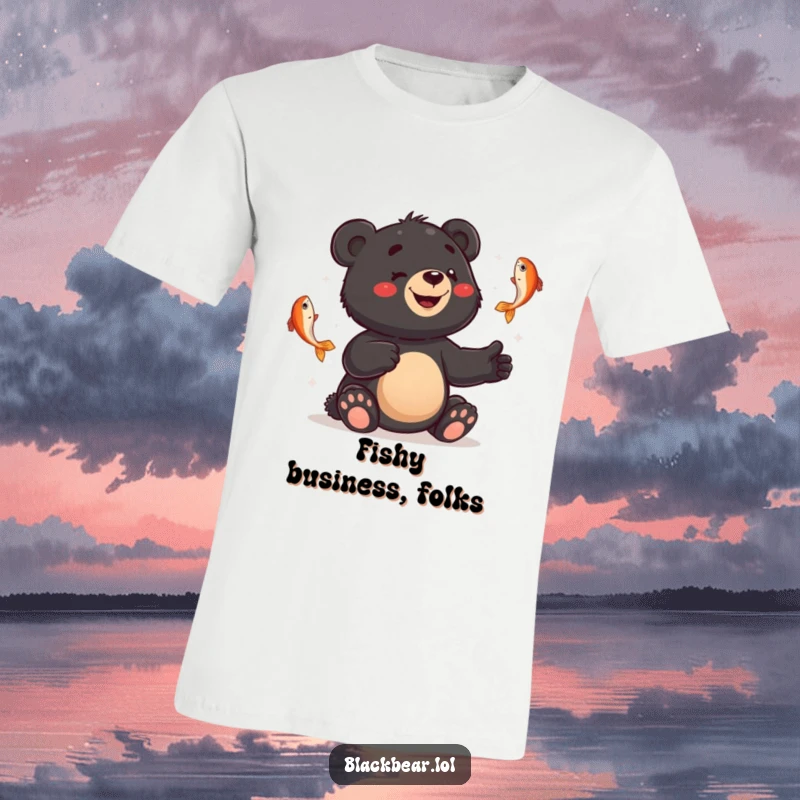 Funny t-shirt of a smiling black bear cub comically juggling fish with a hilariously bewildered expression.