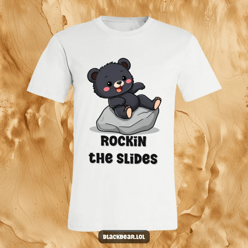 Funny T-Shirt graphic of a black bear cub sliding down a smooth rock with an ecstatic expression, conveying pure fun.