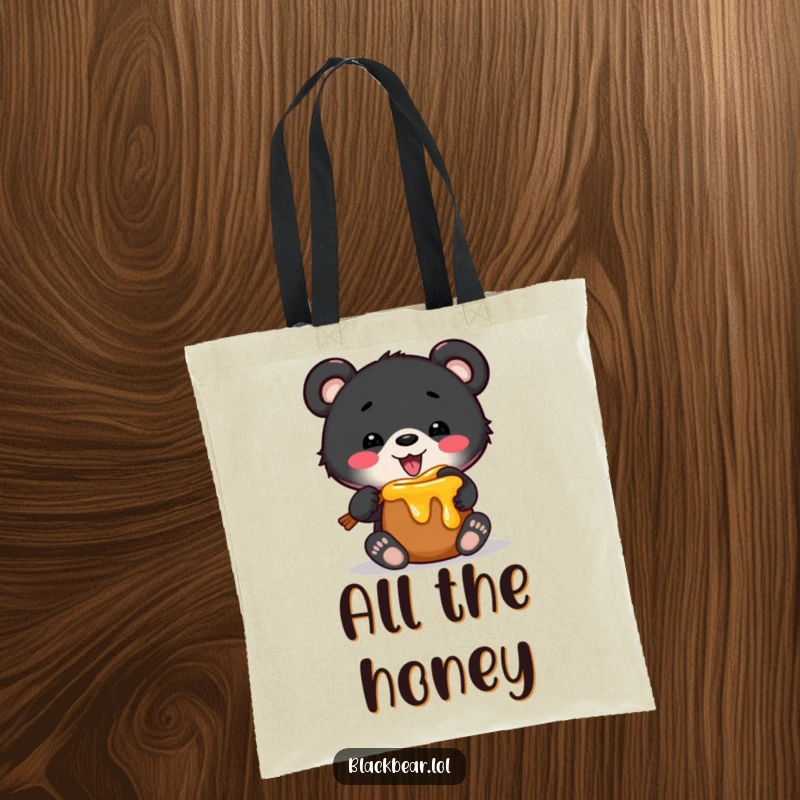 Funny tote bag featuring a black bear cub comically stuck in a miniature honey pot, ideal for carrying groceries with a humorous flair.