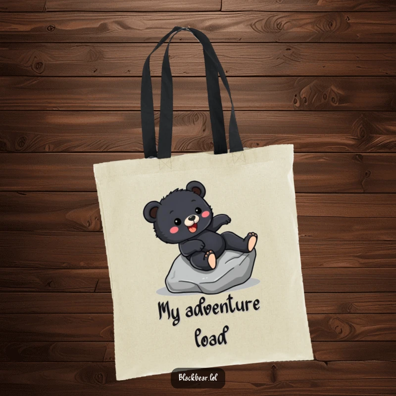 Funny Tote Bag print of a black bear cub sliding down a rock with pure excitement, showcasing a love for adventure.