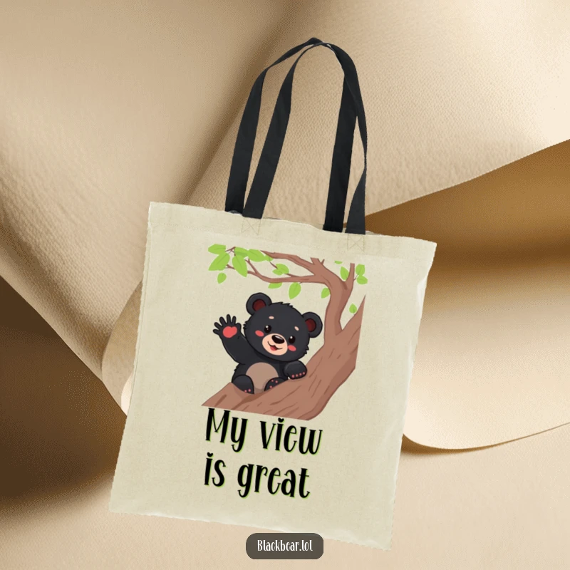 Funny black bear cub waving from a tree branch, featured on a sturdy tote bag, perfect for carrying goods with a smile.