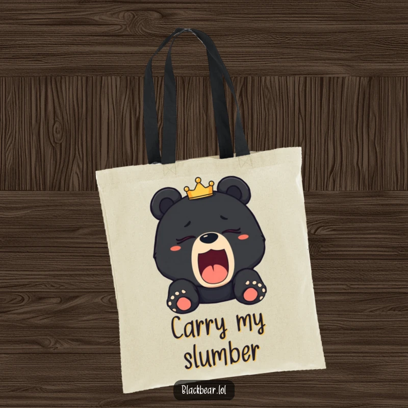 Funny sleepy black bear cub tote bag yawning with a tilted crown, perfect for carrying items with a royal, humorous theme.