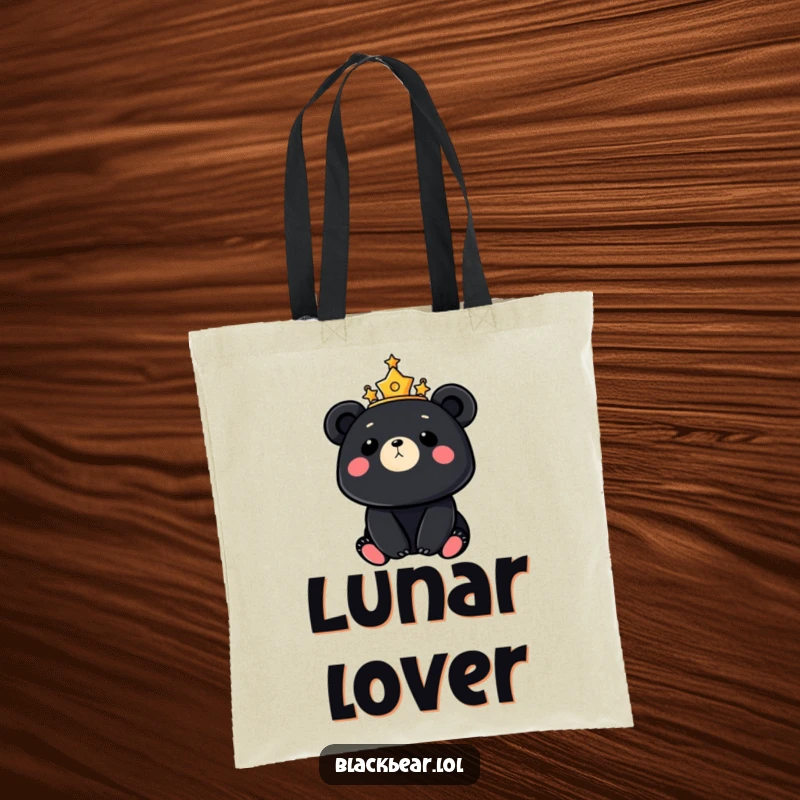 Elegant tote bag featuring a black bear with a crown of stars gazing at the moon, perfect for carrying essentials with celestial flair.